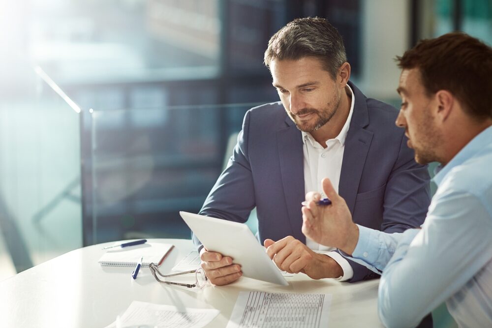 Deux collaborateurs en réunion analysant des données, illustrant les métiers commerciaux et le développement de la relation client - Groupe OCEA