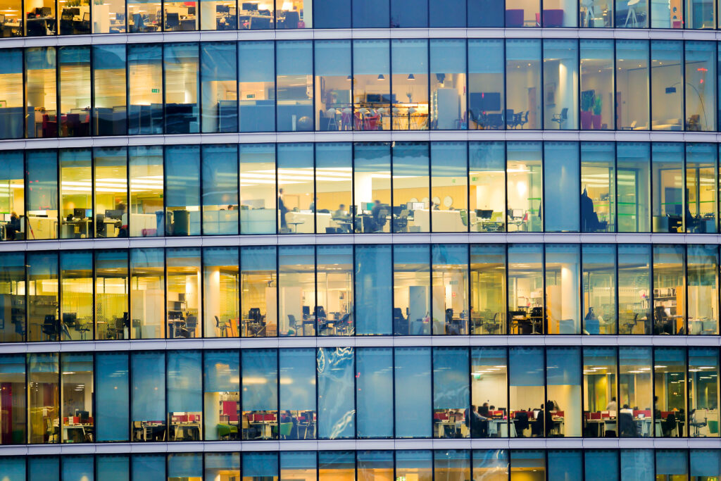 Façade de bureaux modernes avec espaces de travail visibles, illustrant la gestion des consommations d’énergie, l’optimisation des charges et le pilotage des bâtiments tertiaires – OCEA Smart Building – Groupe OCEA