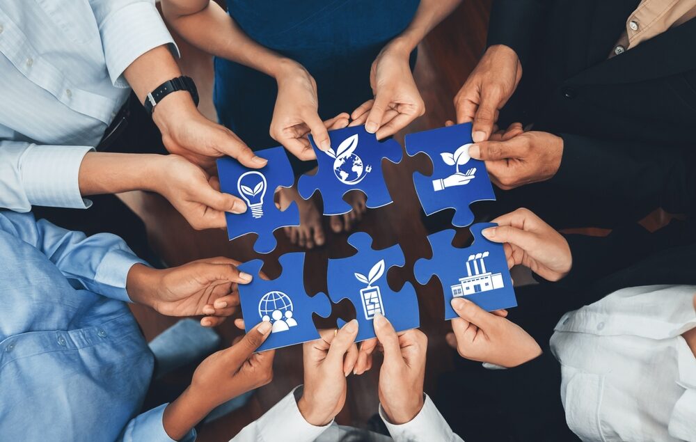 Mains assemblant des pièces de puzzle représentant des symboles environnementaux et sociétaux, illustrant les engagements éthiques et RSE du Groupe OCEA