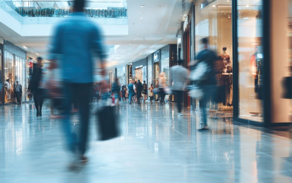 Centre commercial moderne avec flux de visiteurs sur escalators, illustrant la gestion des consommations d’énergie, la maîtrise des charges et l’exploitation des espaces commerciaux – OCEA Smart Building – Groupe OCEA