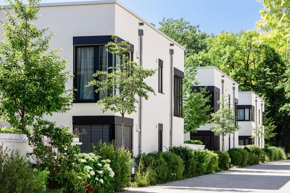 Bâtiments résidentiels modernes entourés de végétation, illustrant la performance environnementale et la gestion durable des ressources dans l’immobilier - Groupe OCEA et OCEA Smart Building