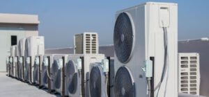 Unités de climatisation installées en toiture d’un bâtiment tertiaire, illustrant la décarbonation des systèmes énergétiques et l’amélioration de la performance et de la valeur des actifs immobiliers - OCEA Smart Building