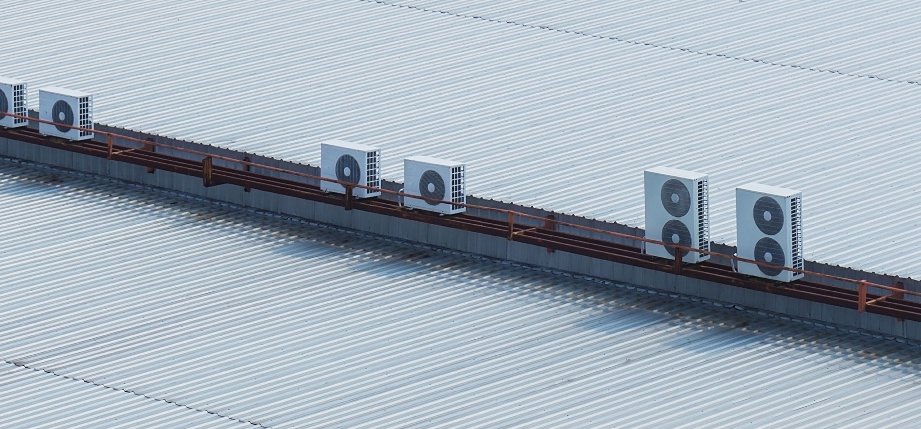 Unités de climatisation installées sur un bâtiment commercial, illustrant des solutions de chauffage et de rafraîchissement décarbonées pour réduire les émissions de CO₂ sans perturber l’activité des sites retail