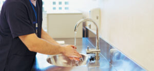 Personnel d’un établissement médico-social utilisant un point d’eau, illustrant la gestion des consommations d’eau et d’énergie et l’optimisation des usages au quotidien - OCEA Smart Building