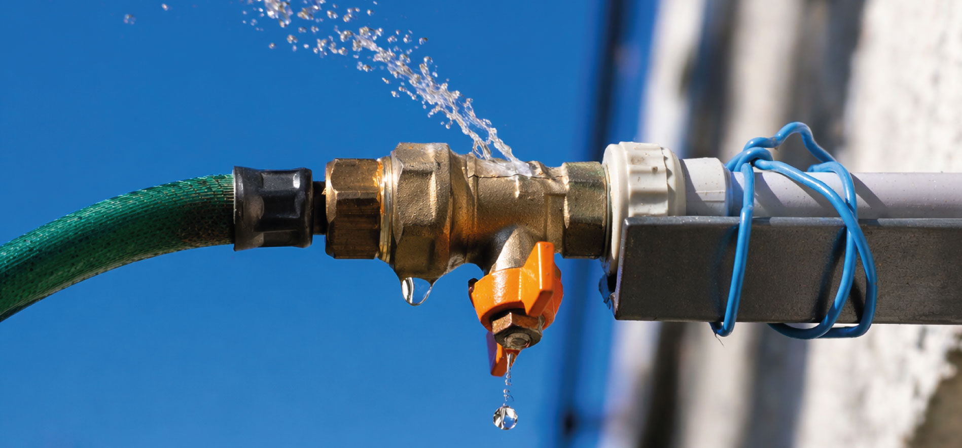 Fuite d’eau sur une canalisation avec gouttes visibles, illustrant la maîtrise des consommations, la détection des pertes et l’optimisation des charges dans les bureaux et bâtiments tertiaires