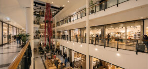 Centre commercial avec boutiques et visiteurs, illustrant la répartition des charges et la gestion des consommations dans l’immobilier commercial et les espaces retail - OCEA Smart Building